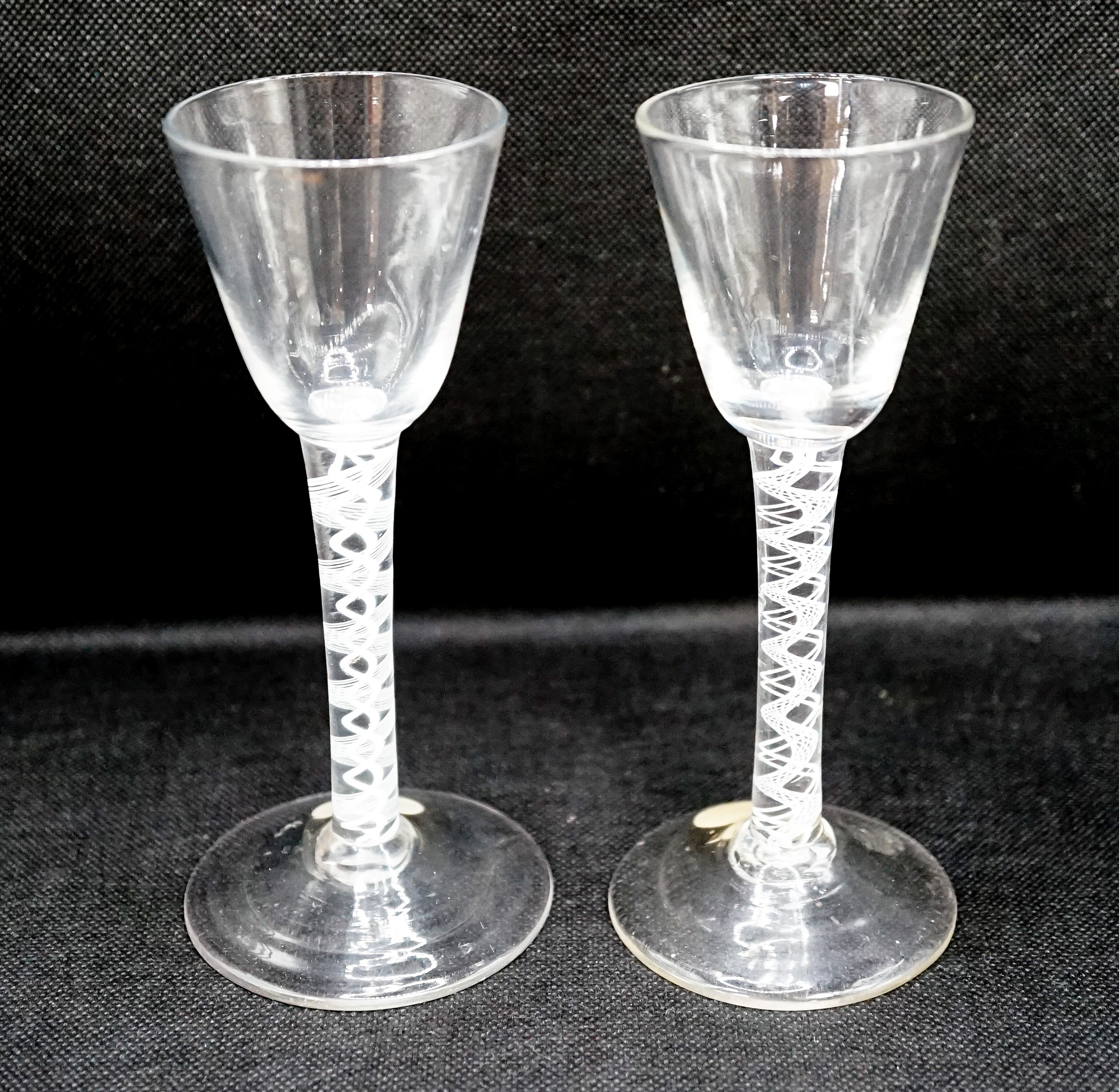 Two George III double series opaque twist stem cordial glasses, c.1765, each with a funnel shaped bowl, 15cm